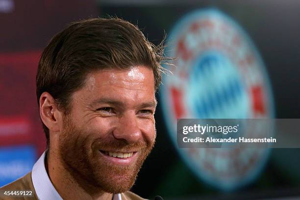 Xabi Alonso of FC Bayern Muenchen smiles during a press conference at Bayern Muenchen's headquarter Saebener Strasse on September 1, 2014 in Munich,...