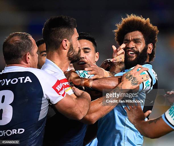 James Tamou of the Cowboys gets involved in a melee with Junior Roqica of the Sharks during the round 25 NRL match between the North Queensland...
