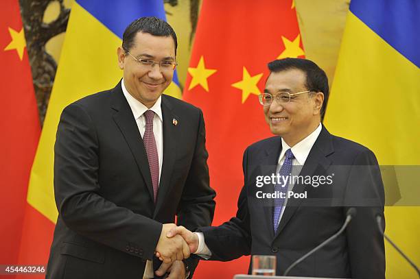 Chinese Premier Li Keqiang shakes hands with Romanian Prime Minister Victor Ponta after a joint news conference at the Great Hall of the People on...