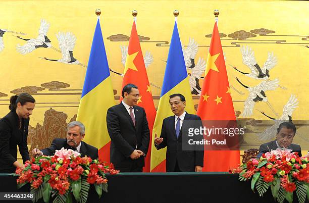 Chinese Prime Minister Li Keqiang talks with Romanian Prime Minister Victor Ponta during a signing ceremony between China and Romania at the Great...