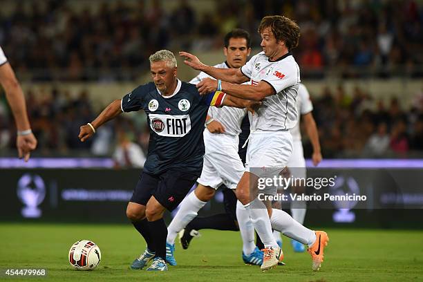 Roberto Baggio is challenged by Diego Lugano during the Interreligious Match For Peace at Olimpico Stadium on September 1, 2014 in Rome, Italy.