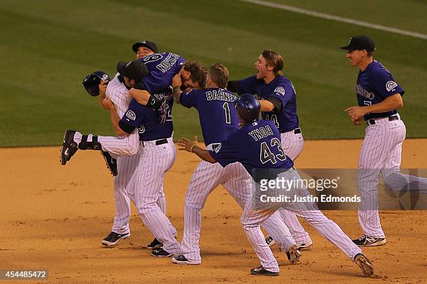 Charlie Blackmon of the Colorado Rockies is mobbed by teammates after hitting an RBI single for the walk-off 10-9 victory against the San Francisco...