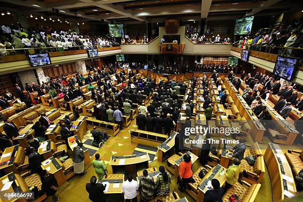 People stand and sing the national anthem during a special joint seating in Parliament in honour of former president Nelson Mandela on December 9,...