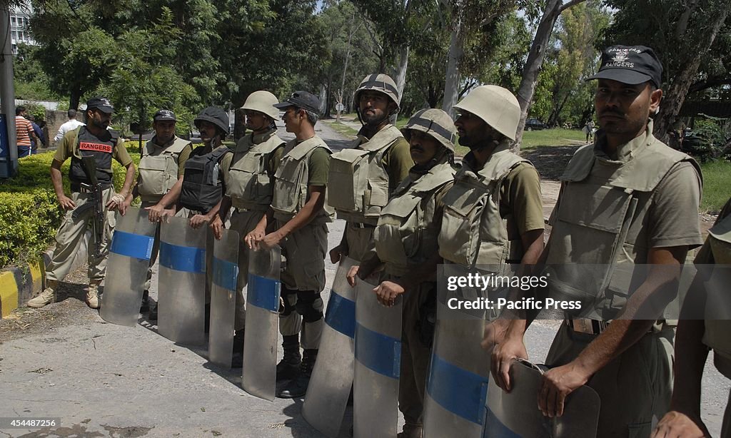 Pakistani soldiers stand alert on a road leading to the...