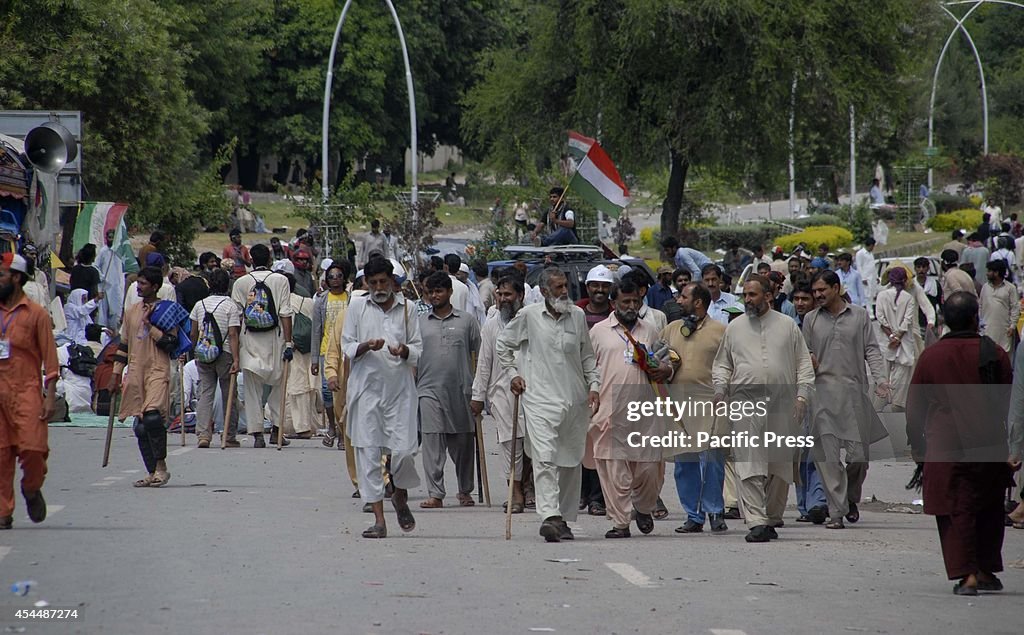 Anti-government protesters walk on a road as clashes...