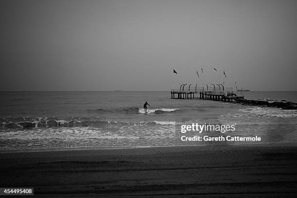 Surfer catches a wave on the Lido di Venezia during the 71st Venice Film Festival on September 1, 2014 in Venice, Italy.