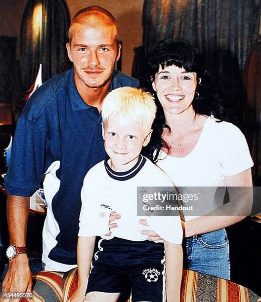 In this handout image supplied by Sainsbury's, David Beckham, Jonnie Peacock, aged 7, and his mother Linda Green pose for a photograph on their first...