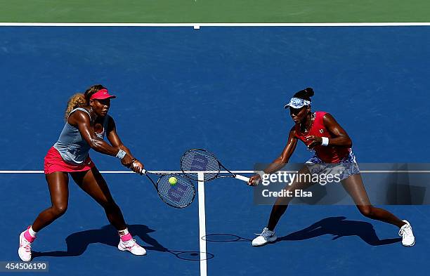 Venus Williams and Serena Williams of the United States return a shot against Ekaterina Makarova and Elena Vesnina of Russia during their women's...