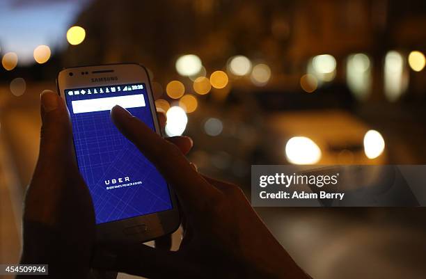 In this photo illustration, a woman uses the Uber app on an Samsung smartphone on September 2, 2014 in Berlin, Germany. Uber, an app that allows...