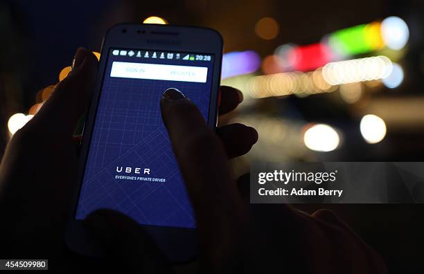 In this photo illustration, a woman uses the Uber app on an Samsung smartphone on September 2, 2014 in Berlin, Germany. Uber, an app that allows...