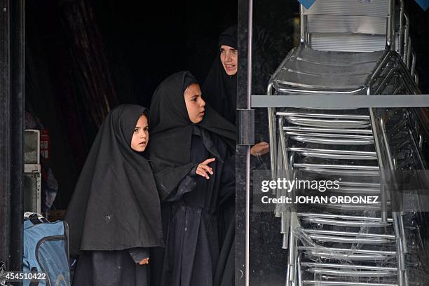 Women members of an ultra-Orthodox Jewish group are seen at the entrance of the building where they will remain in Guatemala City on September 2,...