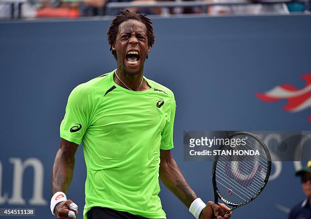 Gael Monfils of France celebrates after winning the second set in a tie-breaker over Grigor Dimitrov of Bulgaria during their 2014 US Open men's...
