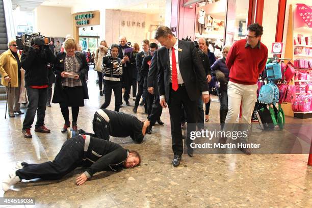 Two men jump on the floor in front of Labour Party leader David Cunliffe as he walks through Riccarton Mall after casting an early vote September 3,...