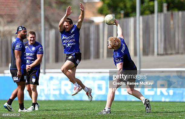 Josh Reynolds jumps in the air as James Graham throws the soccer ball down field during a Canterbury Bulldogs NRL training session at Belmore Sports...