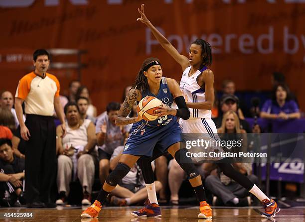 Seimone Augustus of the Minnesota Lynx looks to pass the ball under pressure from DeWanna Bonner of the Phoenix Mercury during game three of the WNBA...