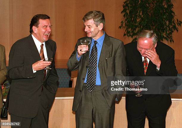 Joschka Fischer, member of the Green Party, Oskar Lafontaine, member of the SPD and Gerhard Schroeder, member of the SPD celebrating after signing...
