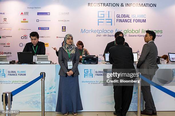 Delegates and staff stand at the registration desk of the Global Islamic Finance Forum in Kuala Lumpur, Malaysia, on Wednesday, Sept. 3, 2014. The...