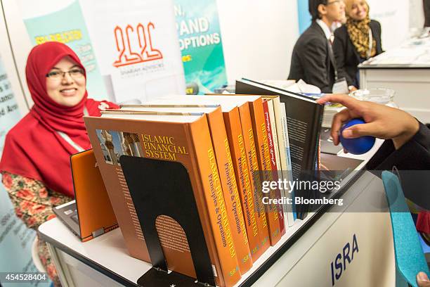 Delegate picks out a book at the International Shari'ah Research Academy for Islamic Finance booth at the Global Islamic Finance Forum in Kuala...