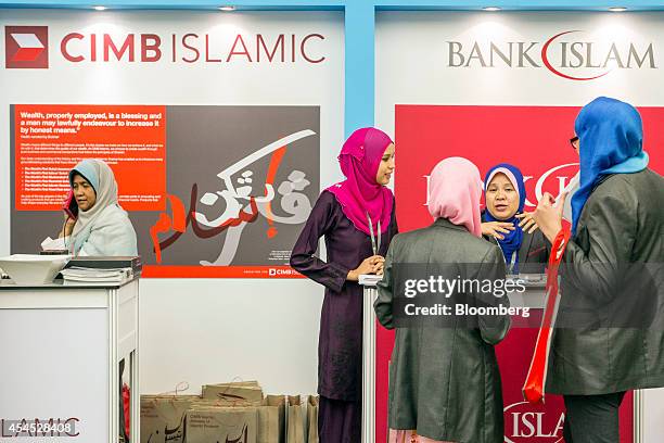 Women stand at the CIMB Islamic Banking Bhd. And the Bank Islam Malaysia Bhd. Booths at the Global Islamic Finance Forum in Kuala Lumpur, Malaysia,...