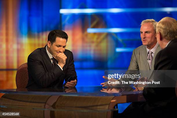 Adam Schefter, left, who has been an NFL Insider at ESPN for five years, checks his cell phone between segments, opposite Trey Wingo , and Bill...