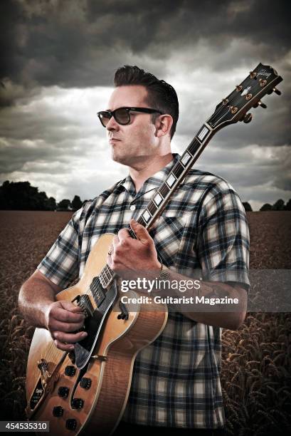 Portrait of English rock musician Darrel Higham, guitarist with Irish rock and blues performer Imelda May, photographed in a wheat field near his...