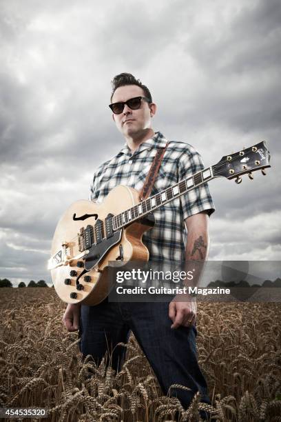 Portrait of English rock musician Darrel Higham, guitarist with Irish rock and blues performer Imelda May, photographed in a wheat field near his...