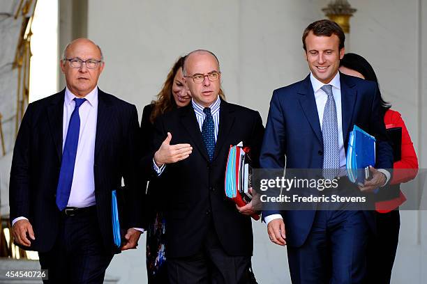 French Finance Minister Michel Sapin , French Interior minister Bernard Cazeneuve and French Minister of Economy Emmanuel Macron leave after a weekly...