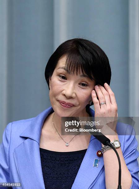 Sanae Takaichi, Japan's newly appointed internal affairs and communications minister, adjusts her hair during a news conference at the prime...