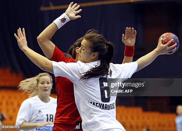 Hungary's Orsolya Verten challenges Tunisia's Faten Yahiaoui during the 2013 Women's Handball World Championship group D match between Tunisia and...