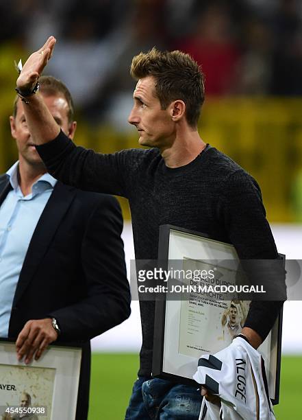 Germany's forward Miroslav Klose waves after recieving an award following his retirement from the national team following their triumph during the...