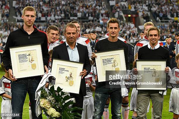 Philipp Lahm, Per Mertesacker, Miroslav Klose and assistant coach Hansi Flick of Germany are honored by DFB President Wolfgang Niersbach and Reinhard...