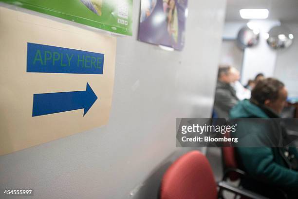 An "Apply Here" sign hangs at a health insurance education and enrollment event in Silver Spring, Maryland, U.S., on Saturday, Dec. 7, 2013....