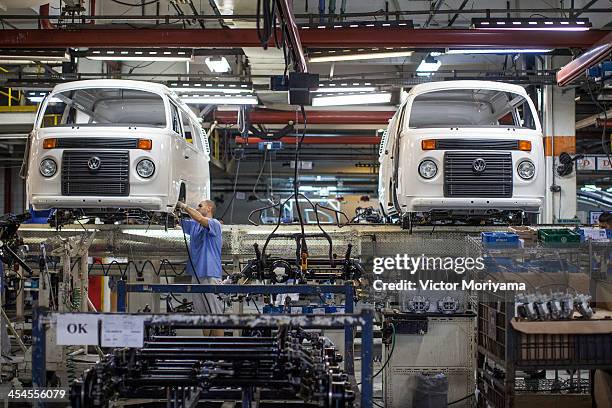 Person works on the production line of the Volkswagen Kombi minibus on December 9, 2013 in Sao Bernardo do Campo, Brazil. The German automaker will...