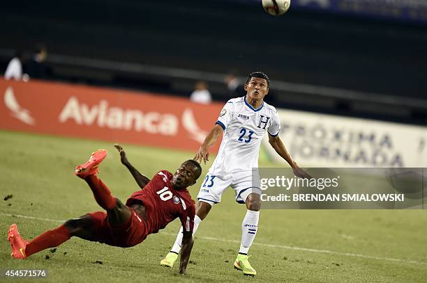 Belize's midfielder Harrison Roches slips as Honduras's midfielder Edder Delgado waits for the ball in the first half during a Central American Cup...
