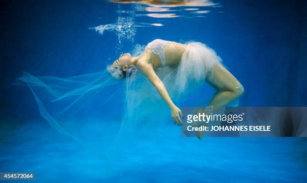 This photo taken on September 3, 2014 shows Chinese bride-to-be Leng Yuting posing underwater for her wedding pictures at a photo studio in Shanghai,...