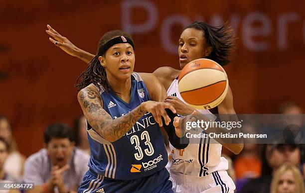 Seimone Augustus of the Minnesota Lynxpasses the ball under pressure from DeWanna Bonner of the Phoenix Mercury during game three of the WNBA Western...