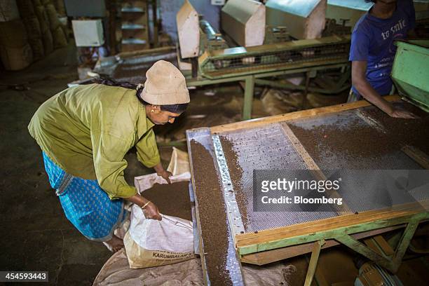 Workers monitor tea as it passes though a fibre extraction machine into bags at the Santosh Tea Industries Pvt. Factory in Coonoor, Tamil Nadu,...