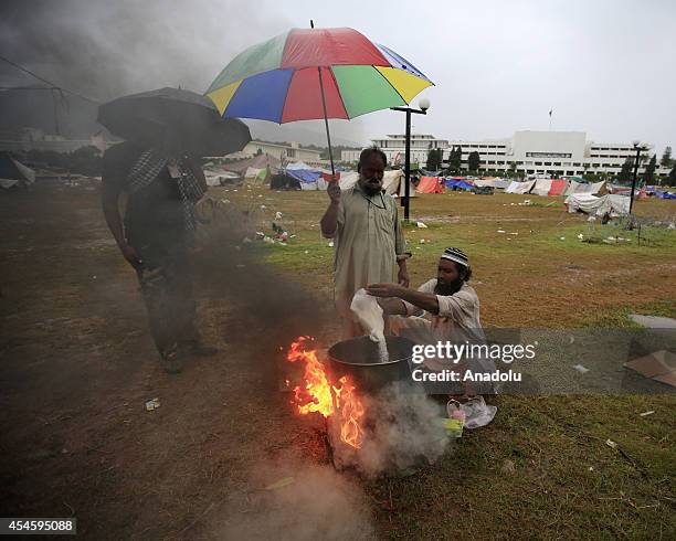 Pakistani anti-government protestor cooks during his waiting at the parliament garden within the ongoing protests in Islamabad, Pakistan on September...