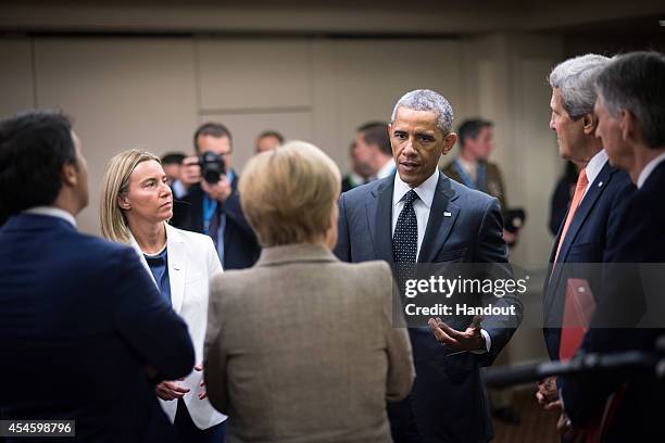 In this handout photo provided by the German Government Press Office , German Chancellor Angela Merkel, the EU's foreign policy chief-designate, the...