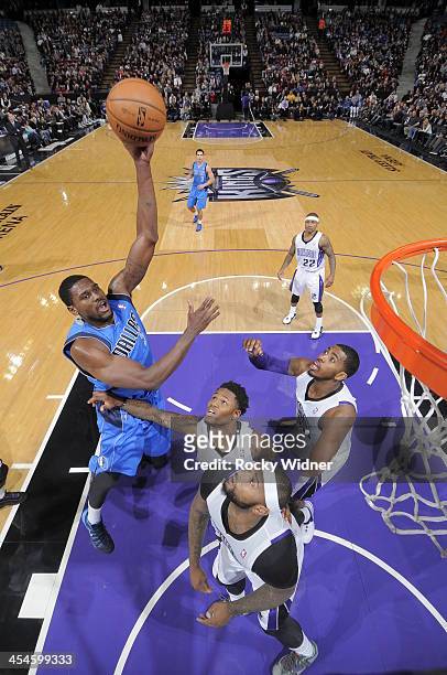 Bernard James of the Dallas Mavericks shoots the ball against Ben McLemore and DeMarcus Cousins of the Sacramento Kings at Sleep Train Arena on...