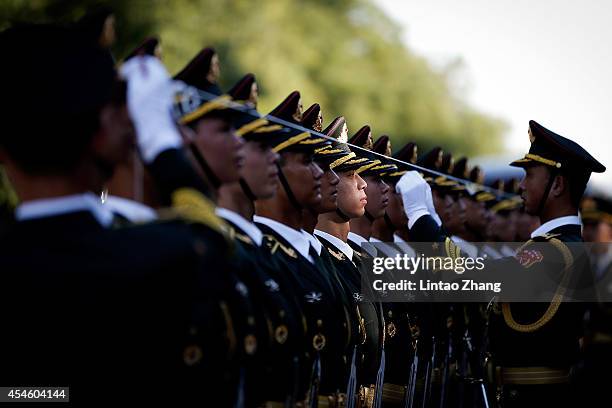 Chinese People's Liberation Army soldiers and officer use ropes to measure positions of honor guard members before a welcoming ceremony for...