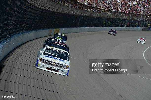 Jason White, driver of the Autism Speaks/NTS Motorsports Chevrolet, leads a pack of trucks during the NASCAR Camping World Truck Series Careers For...