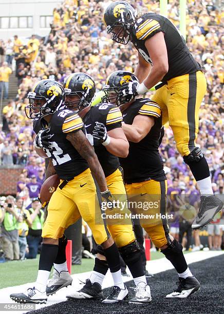 Wide receiver Damond Powell is congratulated by center Austin Blythe of the Iowa Hawkeyes after scoring a touchdown during the fourth quarter against...