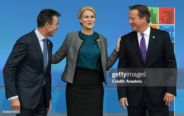 Danish Prime Minister Helle Thorning-Schmidt speaks with NATO Secretary General Anders Fogh Rasmussen and British Prime Minister David Cameron as she...