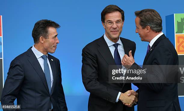 Dutch Prime Minister Mark Rutte speaks with NATO Secretary General Anders Fogh Rasmussen and British Prime Minister David Cameron as he arrives for...