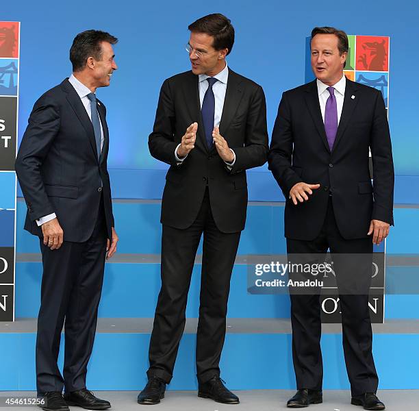 Dutch Prime Minister Mark Rutte speak with NATO Secretary General Anders Fogh Rasmussen and British Prime Minister David Cameron as he arrives for...