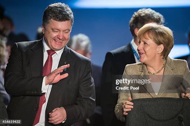 German Chancellor Angela Merkel talks with Ukrainian President Petro Poroshenko during a working session on Ukraine on the first day of the NATO...