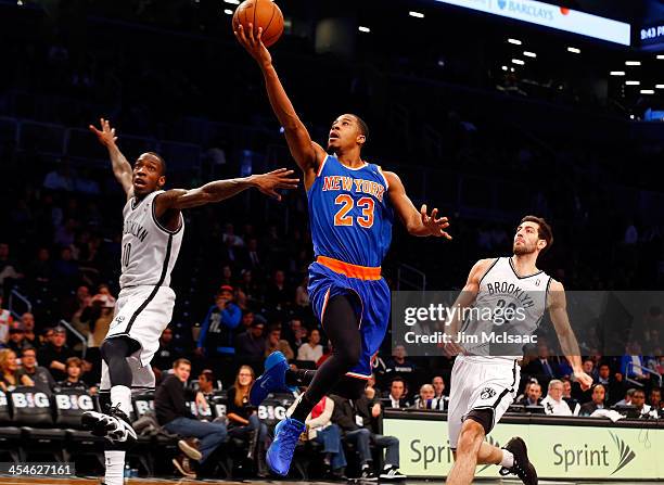 Toure' Murry of the New York Knicks in action against Tyshawn Taylor and Tornike Shengelia of the Brooklyn Nets at Barclays Center on December 5,...