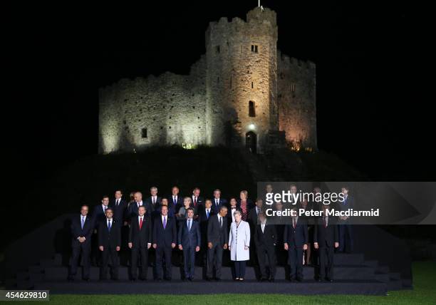 President Barack Obama, British Prime Minister David Cameron and NATO Secretary General Anders Fogh Rasmussen talk as they pose with other leaders...