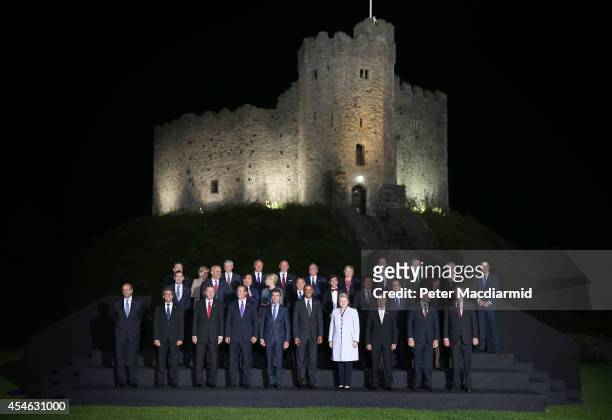 President Barack Obama, British Prime Minister David Cameron and NATO Secretary General Anders Fogh Rasmussen talk as they pose with other leaders...